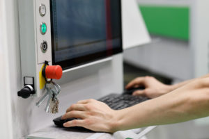 Dental staff operating a CAD/CAM machine.