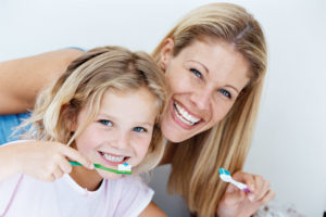 Mother and daughter brushing their teeth.