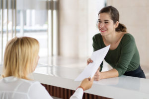 Receptionist sharing information with a patient.